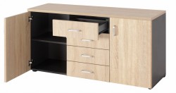 Widok na komodę drzwiami otwartymi i wysuniętymi szufladami